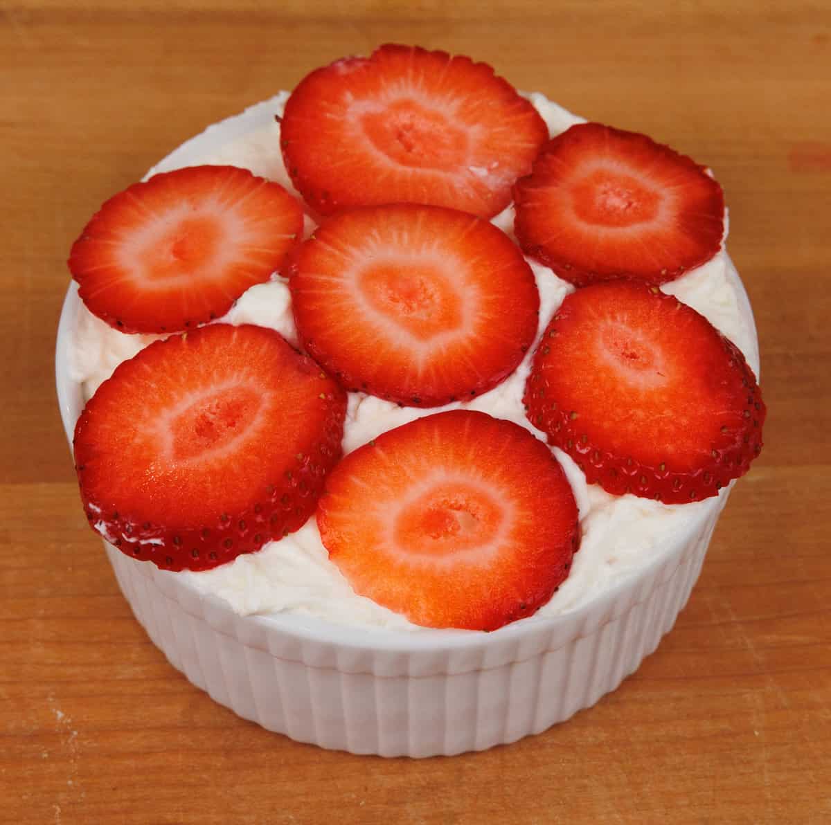 assembling a small strawberry icebox cake in a ramekin.