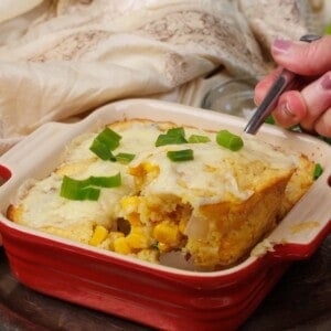 a spoon scooping out a portion of homemade corn pudding