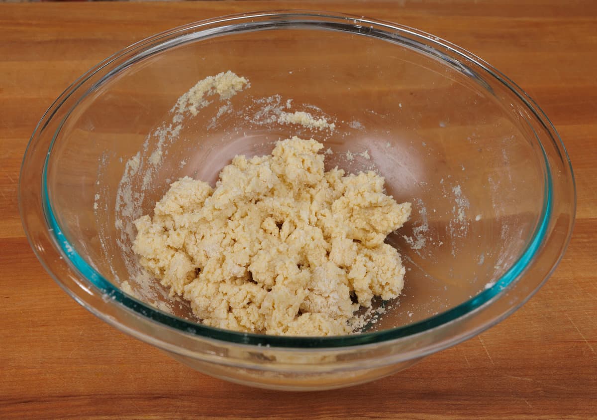 glass mixing bowl containing the dry and wet ingredients combined for the strawberry scones.