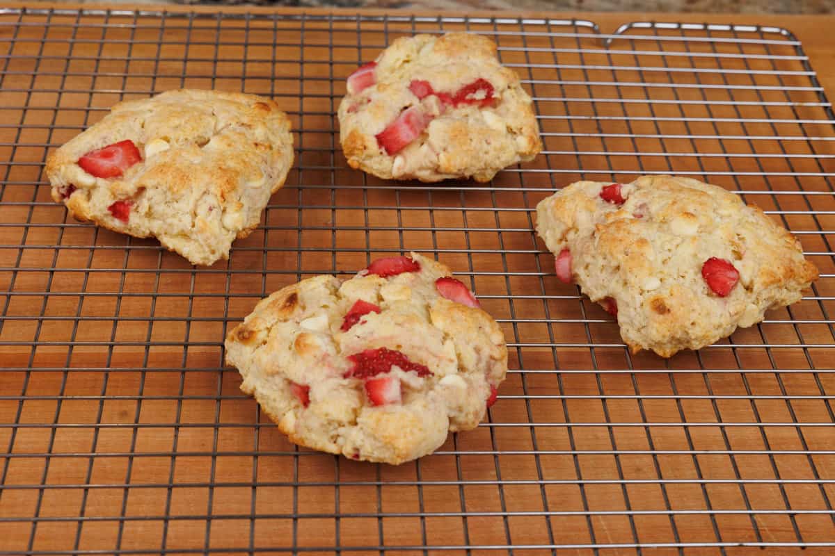 four strawberry scones on a cooling rack after baking.
