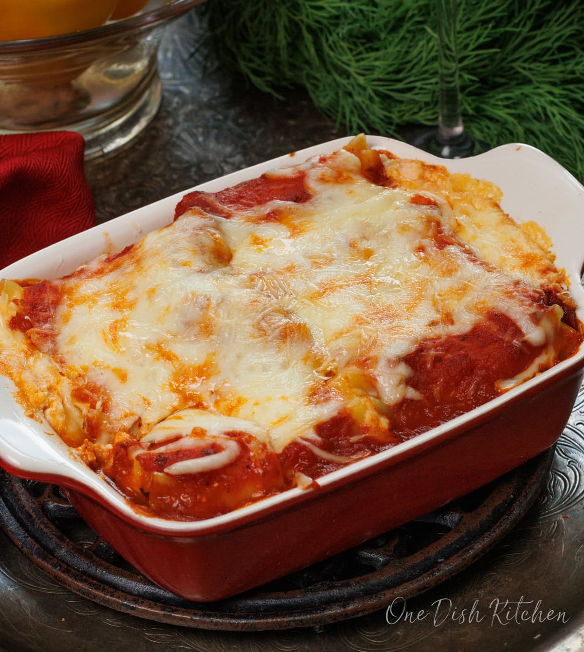 a small vegetarian lasagna in a red baking dish.