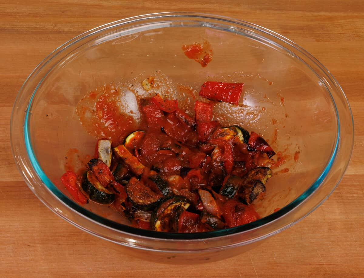 cooked vegetables mixed with tomato sauce in a bowl