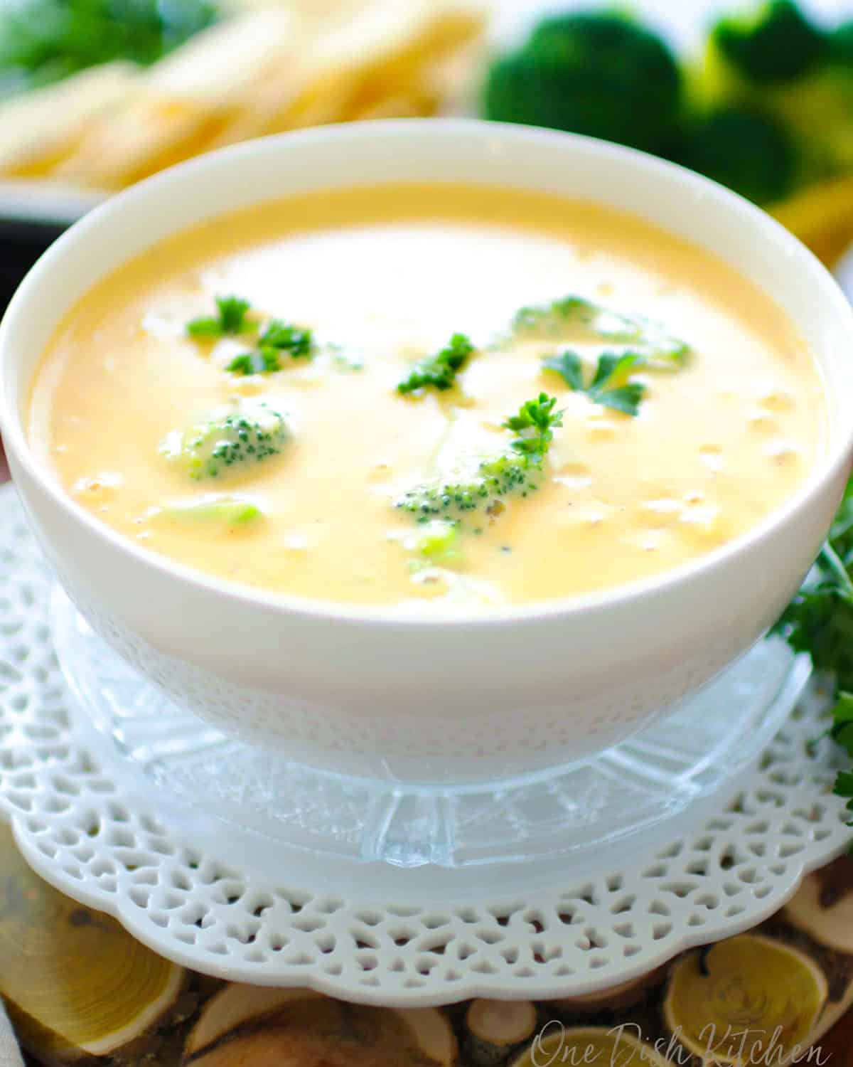 a single serving of broccoli cheddar soup in a white bowl.
