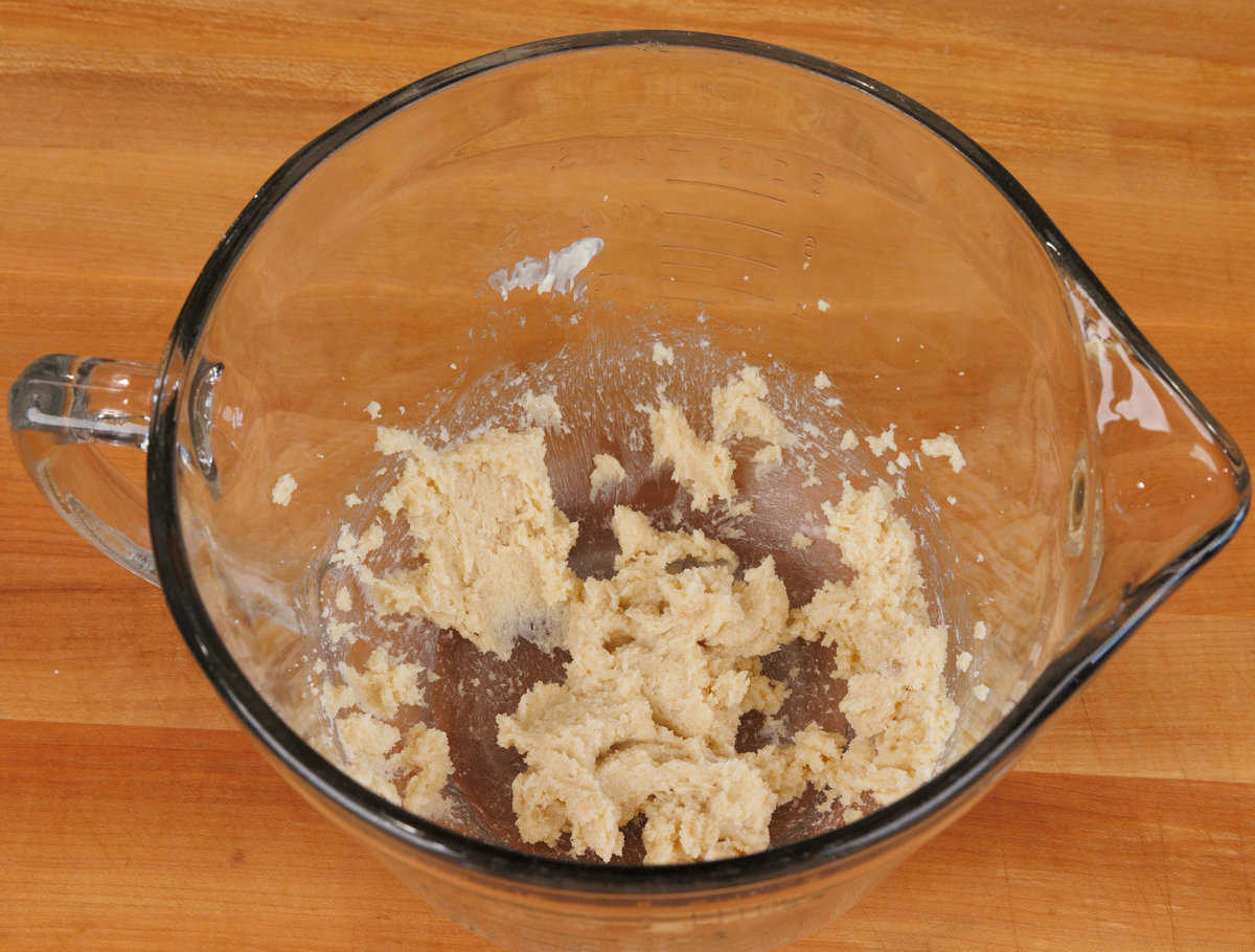 softened butter and sugar mixing together in a mixing bowl with an electric beater on the side