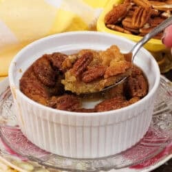 a small crustless pecan pie in a ramekin with a spoon on the side.