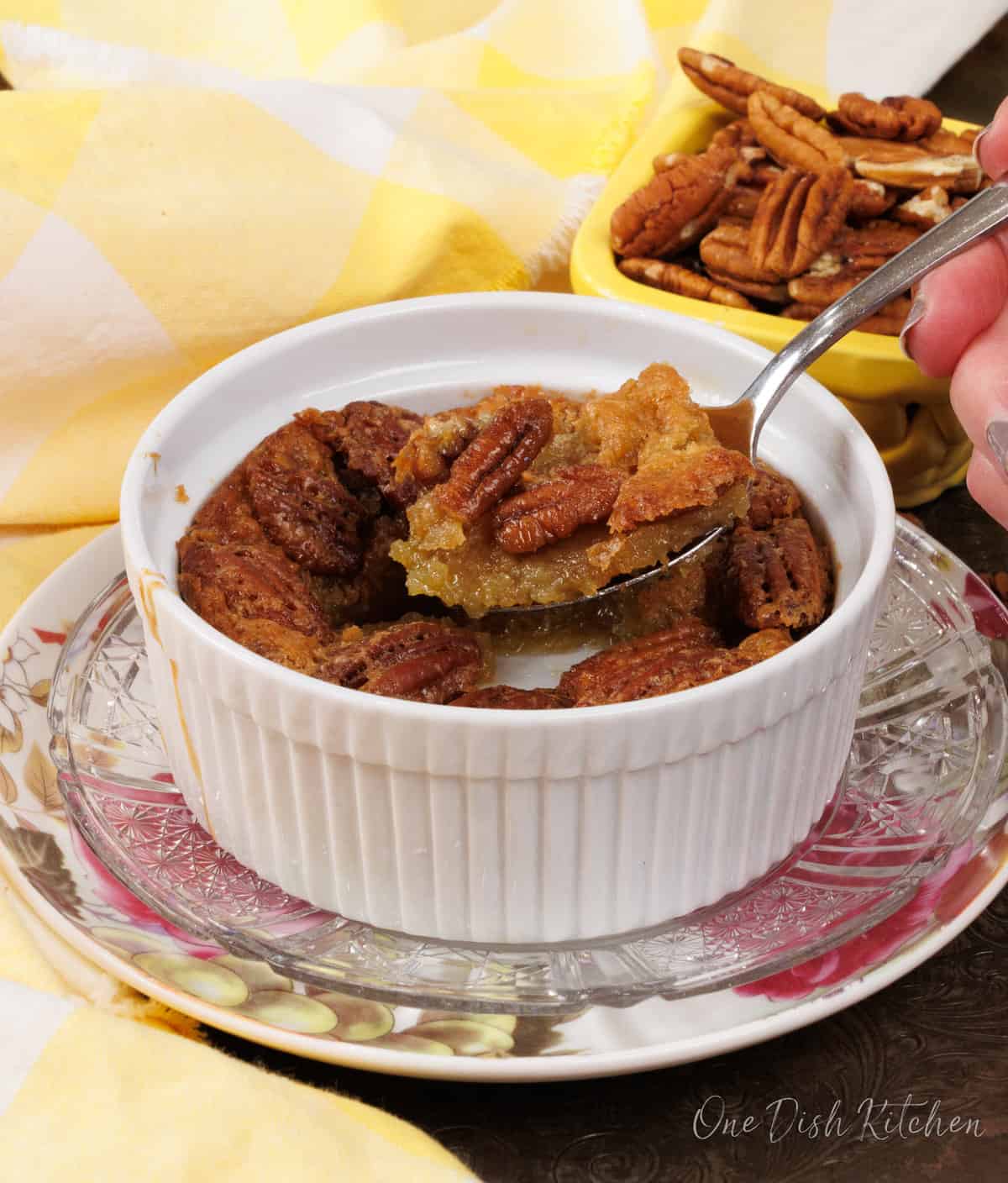 a spoonful of crustless pecan pie over a larger bowl of the pie