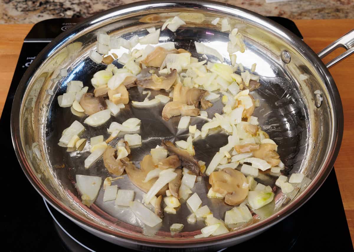 onions, garlic, and mushrooms cooking in a skillet