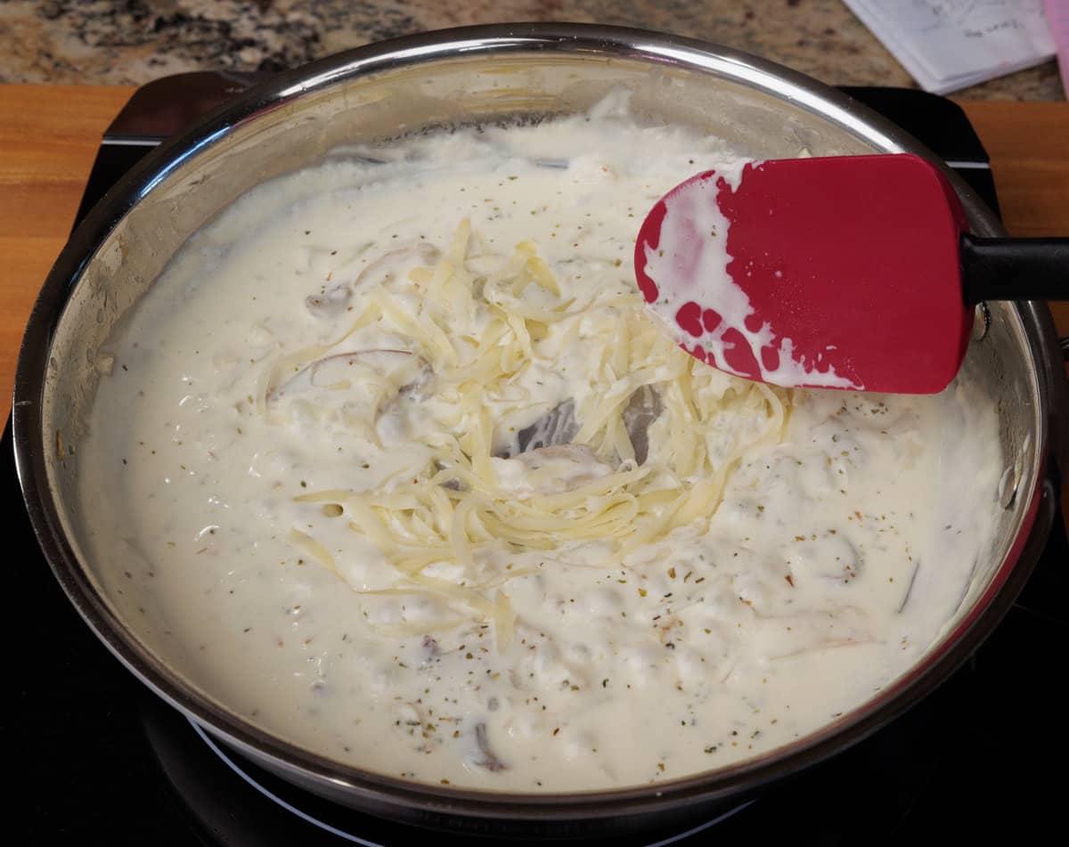 cheese added to a sauce in a skillet