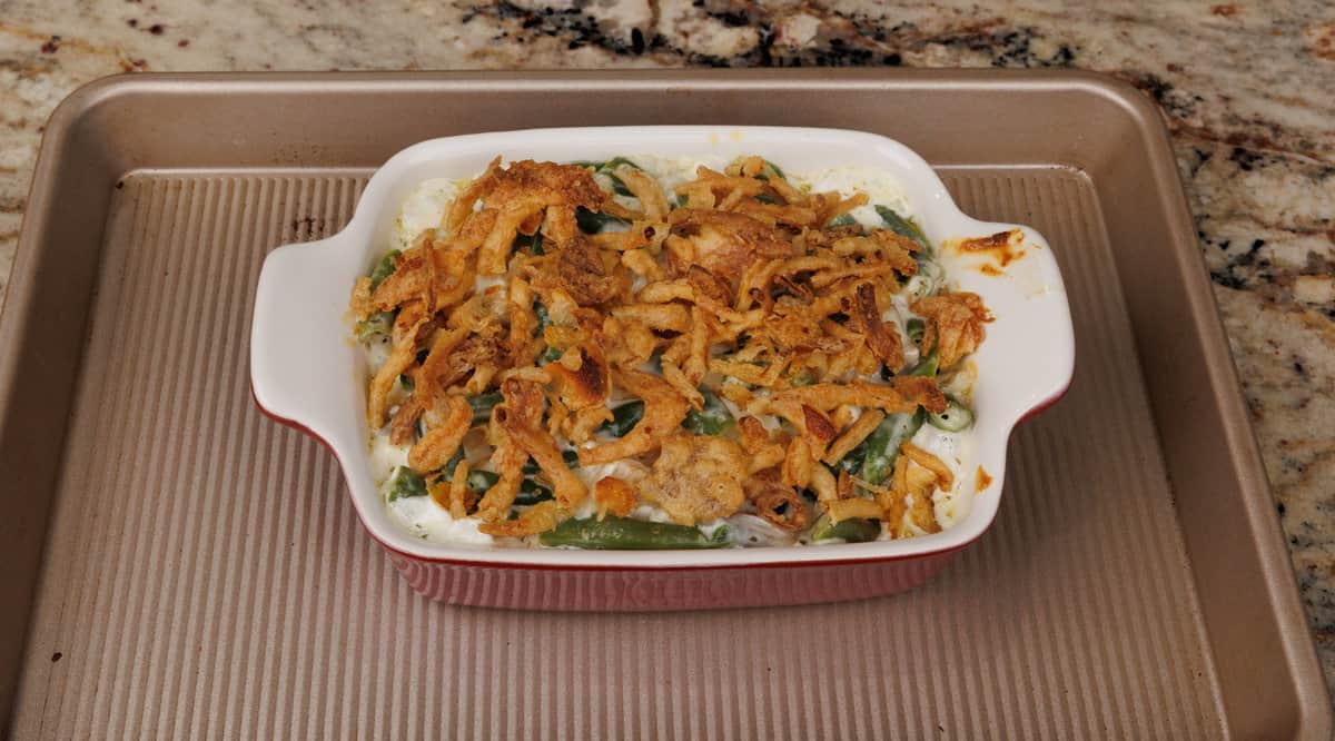 a fully baked green bean casserole on a rimmed baking sheet on a kitchen counter