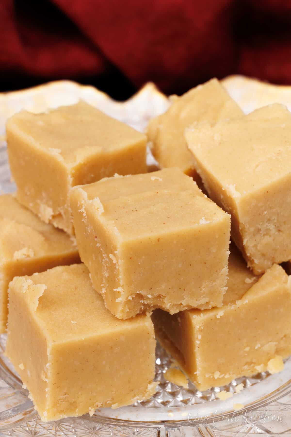 squares of peanut butter fudge on a white plate next to a red napkin