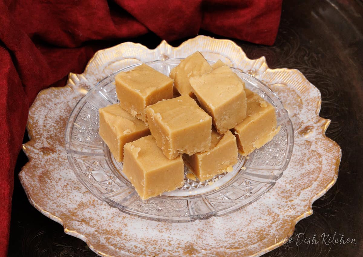 squares of peanut butter fudge on a white plate next to a red napkin