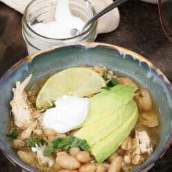 white chicken chili in a bowl with avocado and sour cream on top