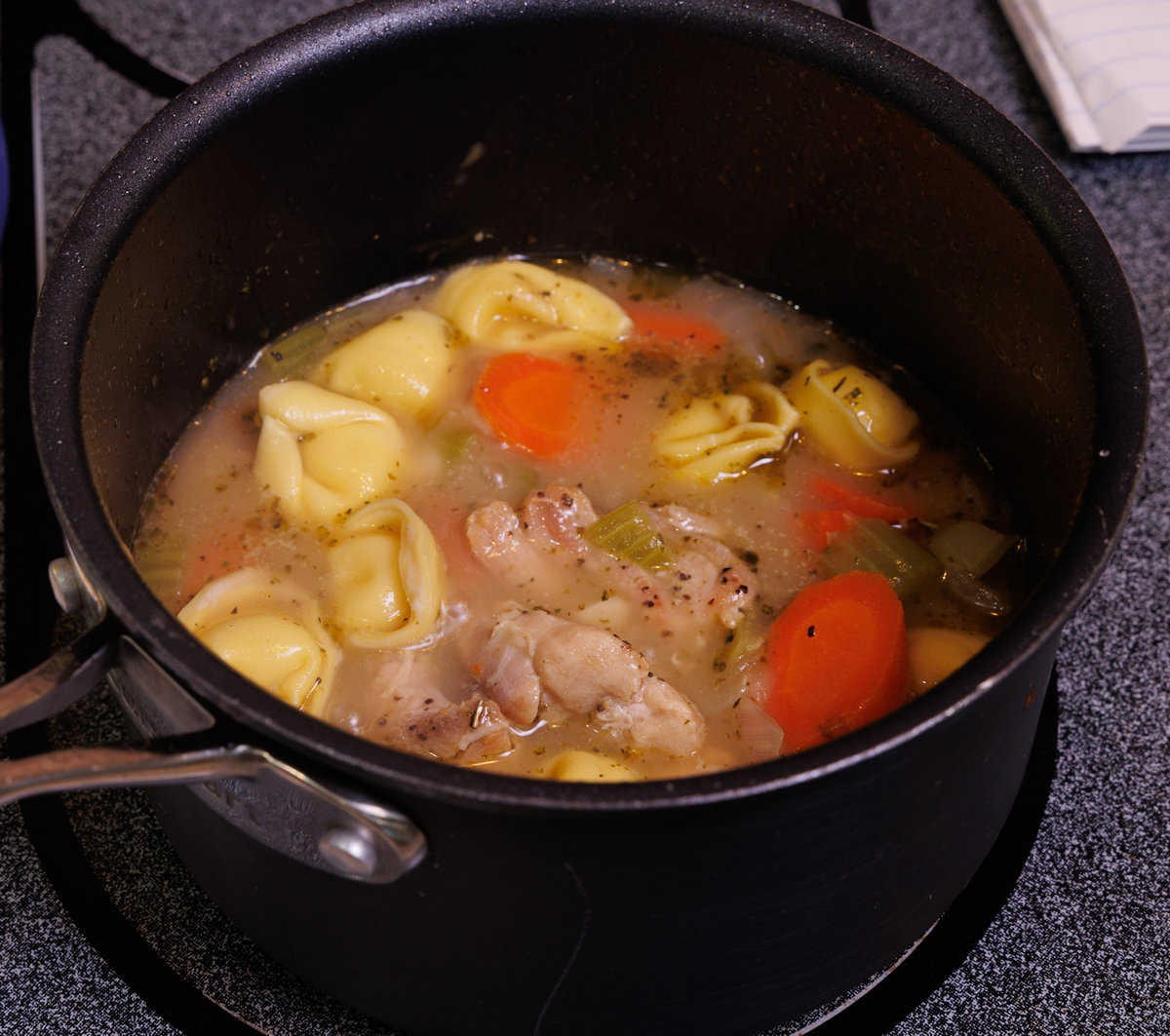 tortellini soup simmering in a pot