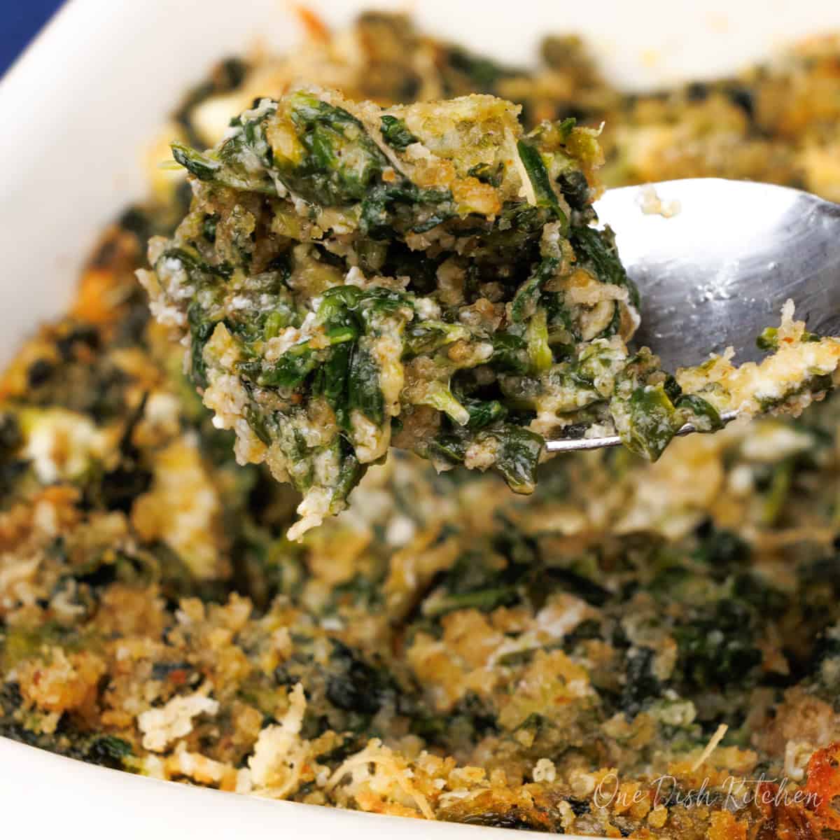 a spoonful of steakhouse-style creamed spinach over a dish.