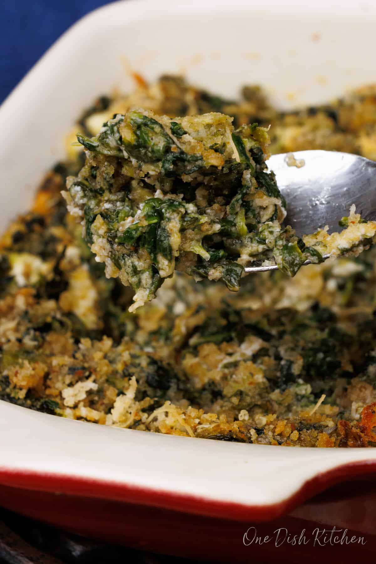 a spoonful of creamed spinach over a baking dish