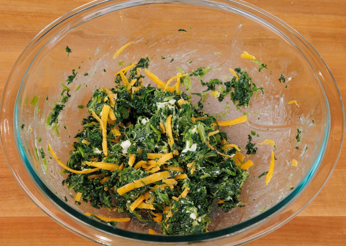 spinach, cheese, and seasoning in a mixing bowl