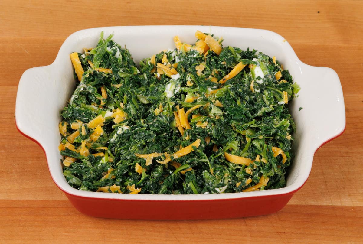 spinach casserole in a small baking dish on a kitchen counter