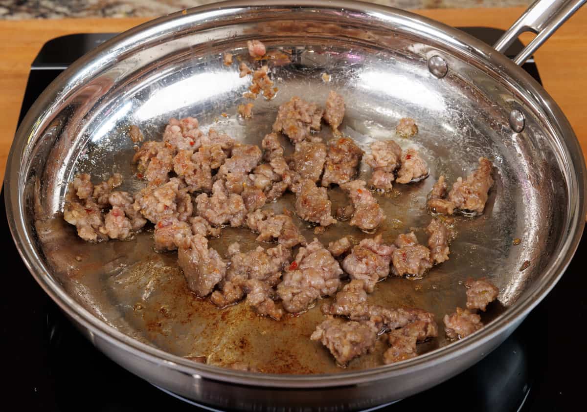 ground italian sausage cooking in a skillet