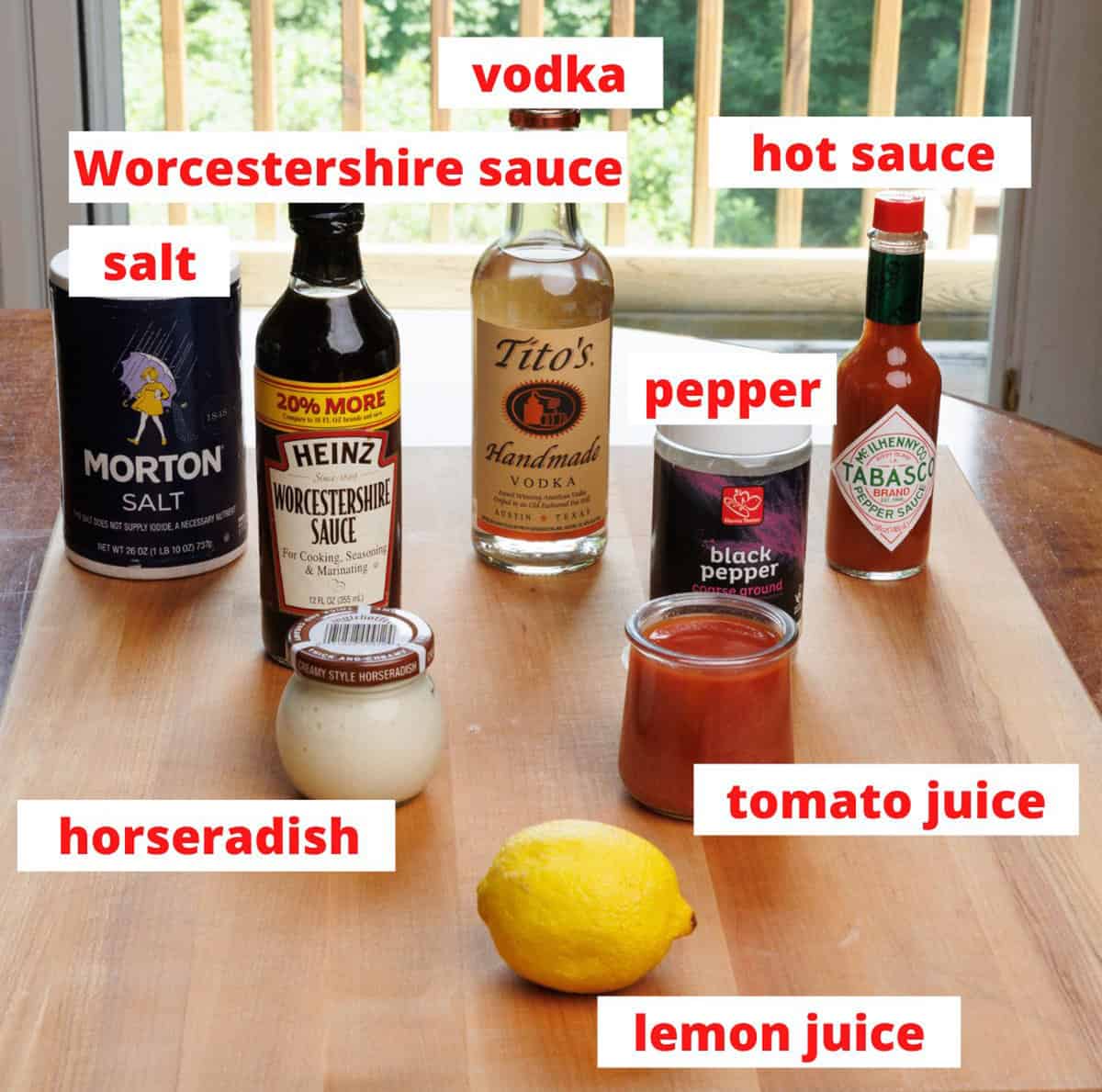 bloody mary ingredients on a kitchen table next to a large window