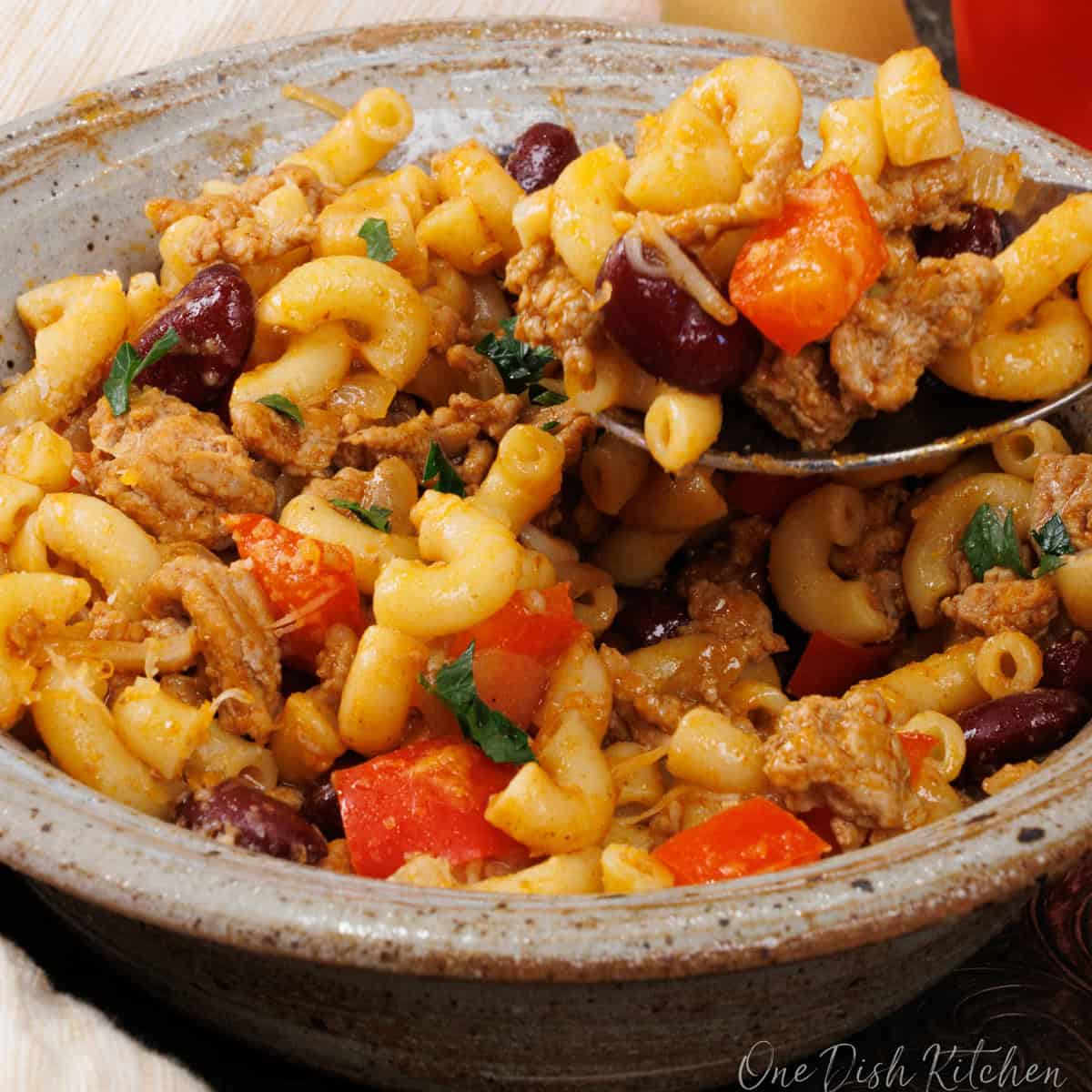 chili mac in a bowl next to a white napkin.