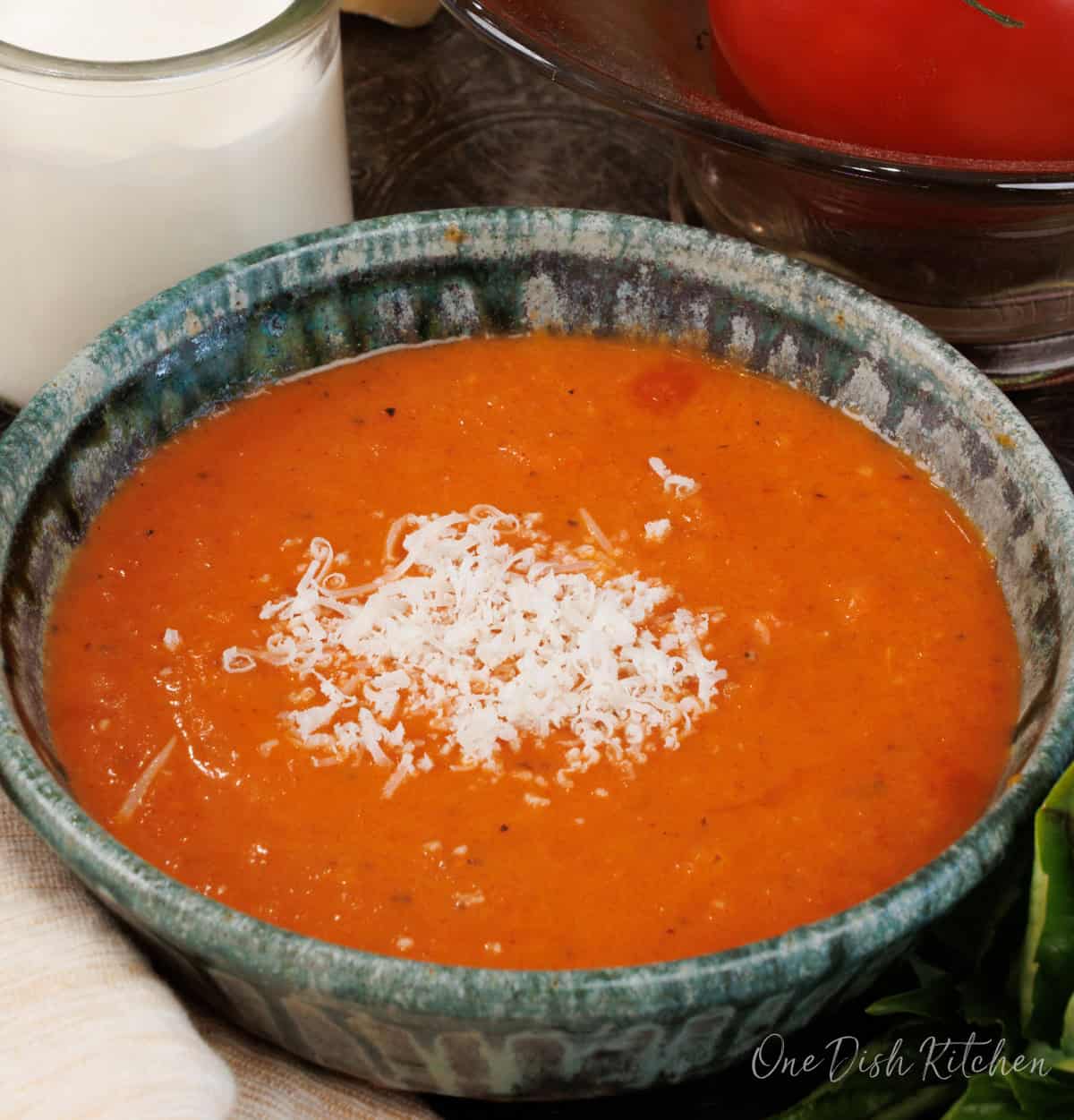a single serving of creamy tomato soup topped with parmesan cheese.