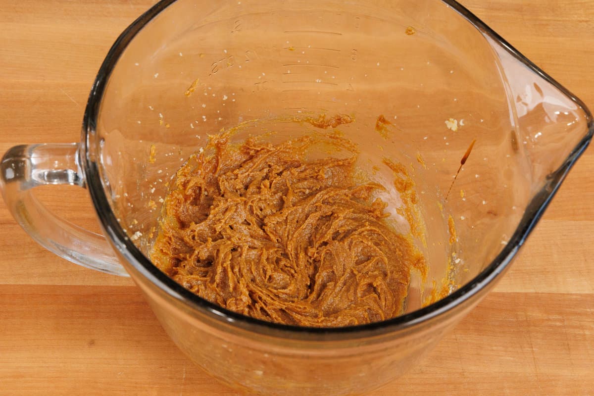 butter and brown sugar in a mixing bowl on a wooden counter