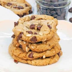 four oatmeal chocolate chip cookies on top of each other on a plate.
