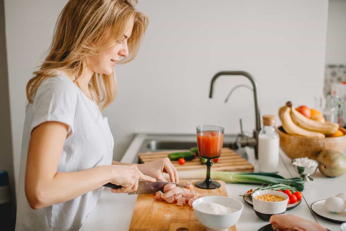 a woman in the kitchen reducing a recipe so she can feed herself.