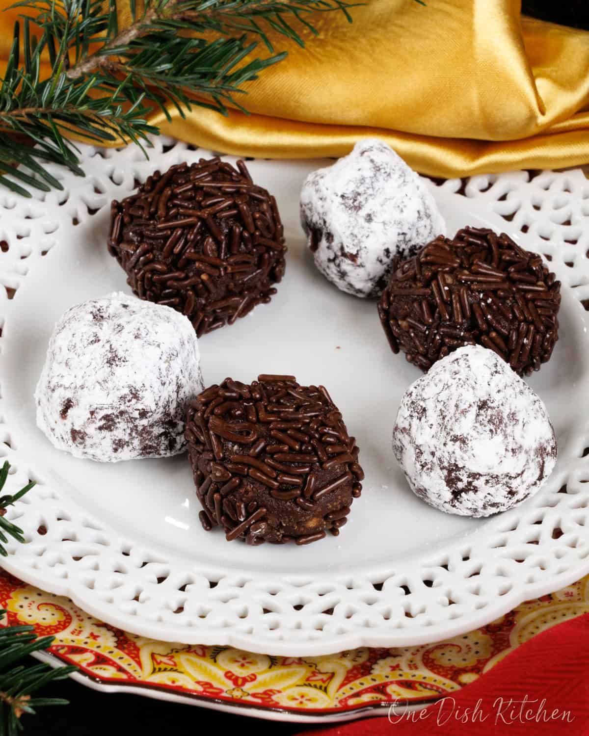 a small batch of rum balls on a white plate.