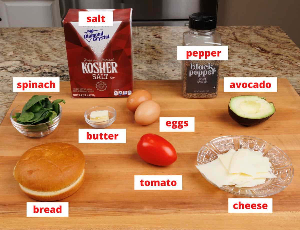 breakfast sandwich ingredients on a wooden cutting board on a kitchen counter