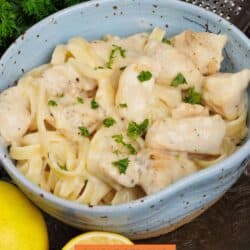 a blue bowl filled with chicken alfredo.