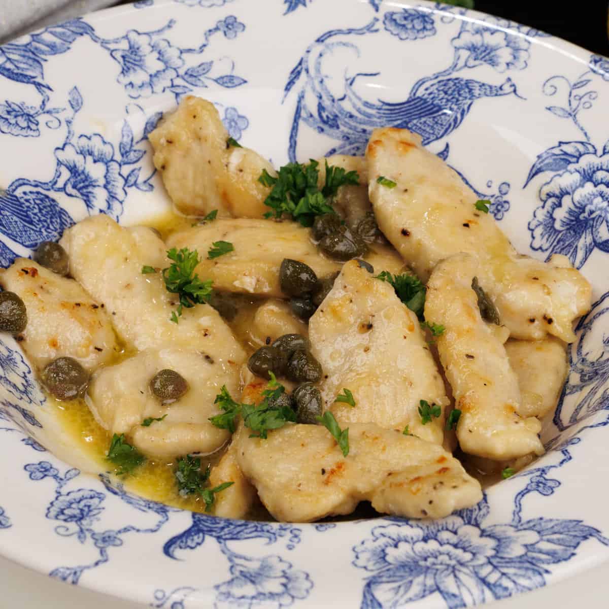 homemade chicken piccata in a bowl on a silver tray