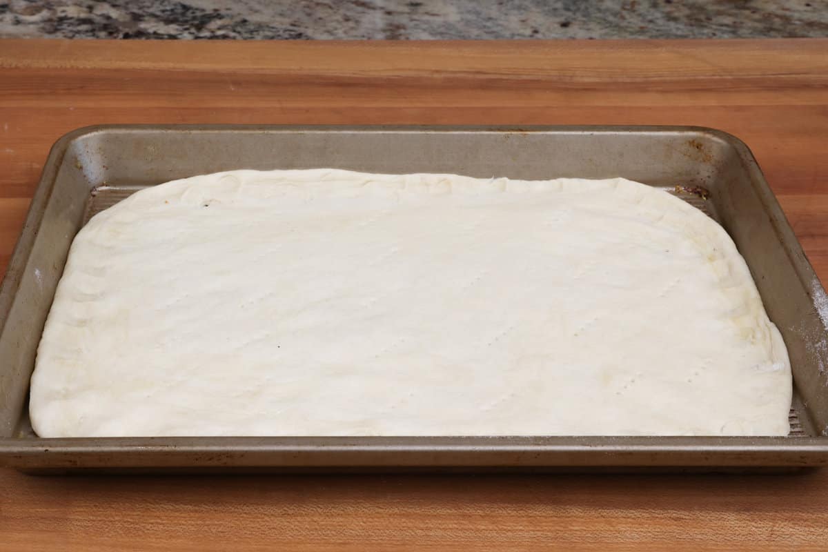 pizza dough stretched over a 9x13 baking pan.