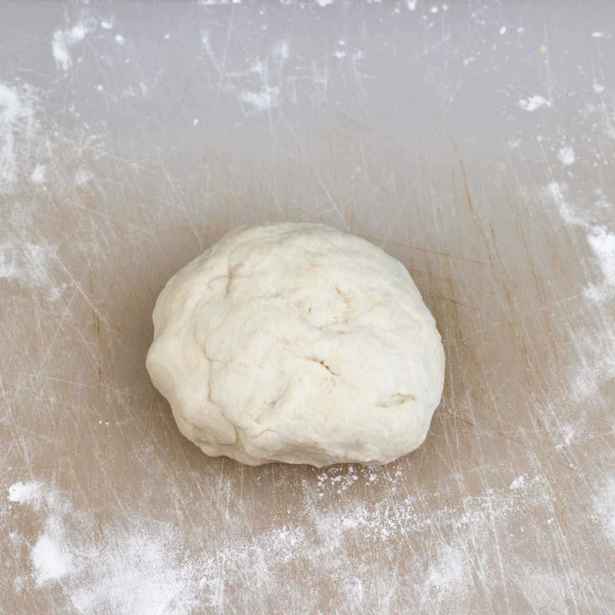 pizza dough on a floured surface after kneading
