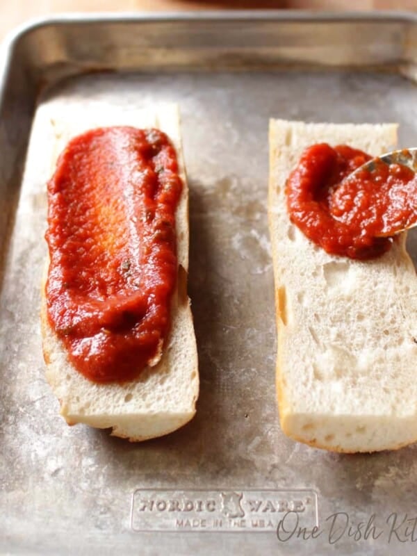 pizza sauce spooned over two slices of french bread