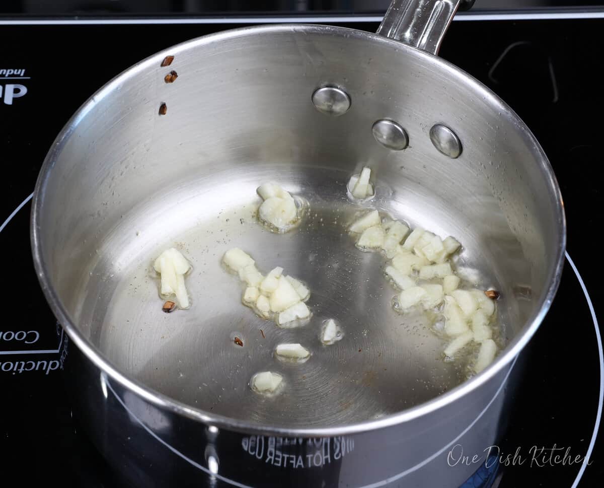 minced garlic cooking in a small saucepan.