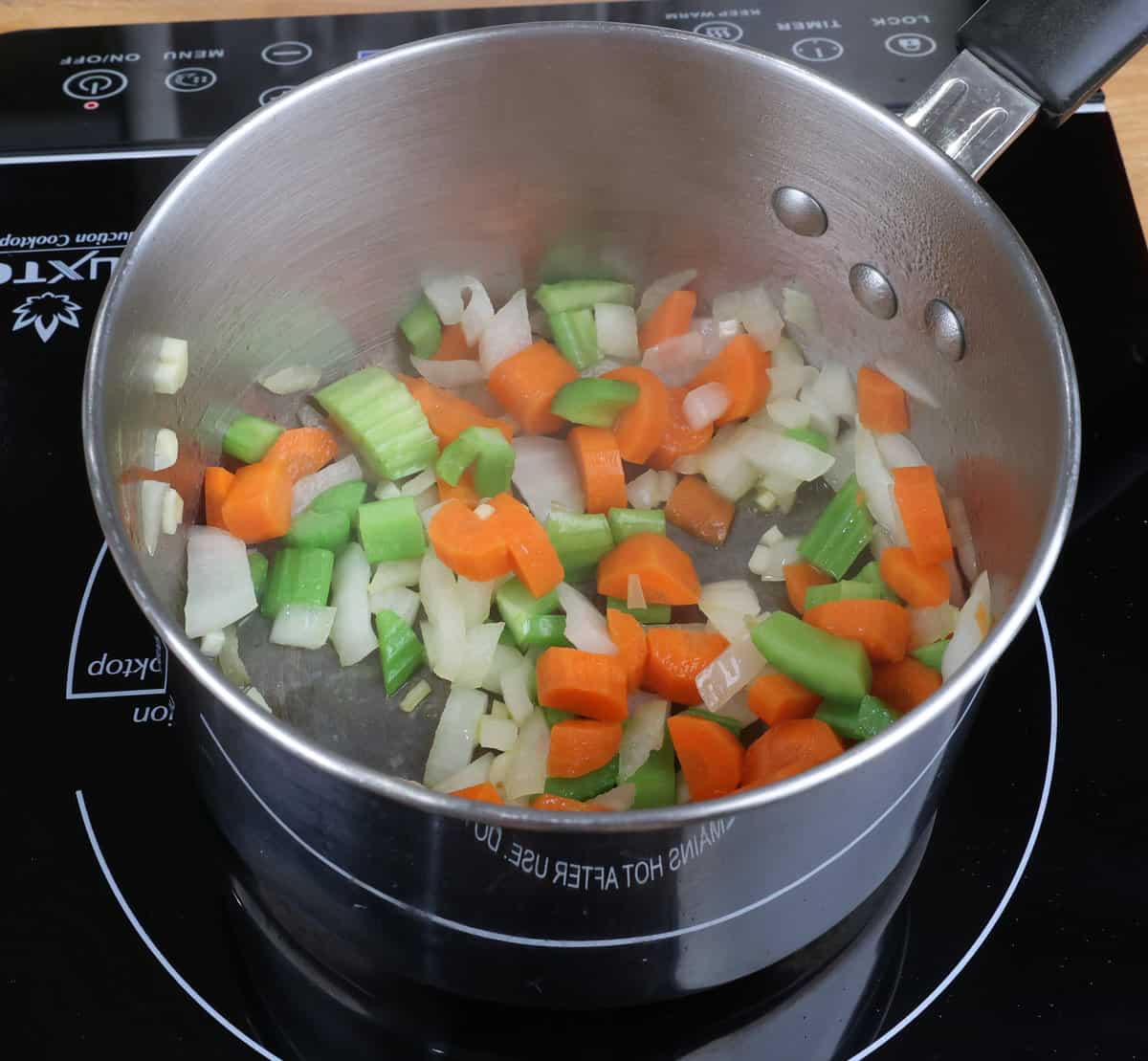 chopped onions, carrots, celery, and garlic sauteeing in a small pot.
