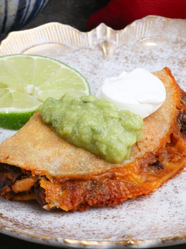 one crispy baked black bean taco topped with sour cream and guacamole.