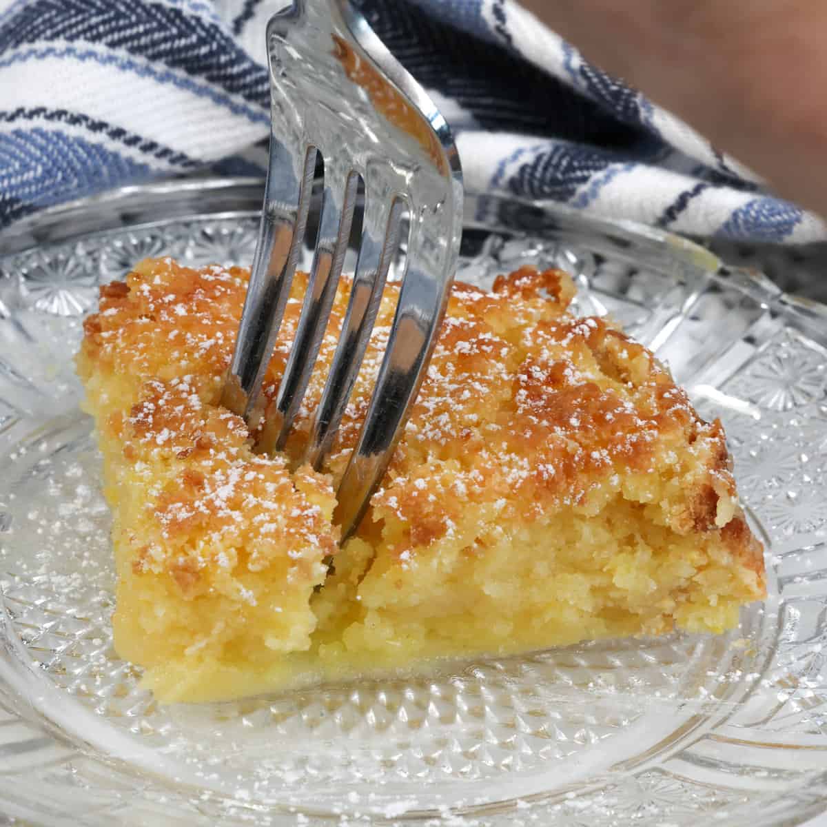 a square slice of chess pie with a fork in the center of the pie.