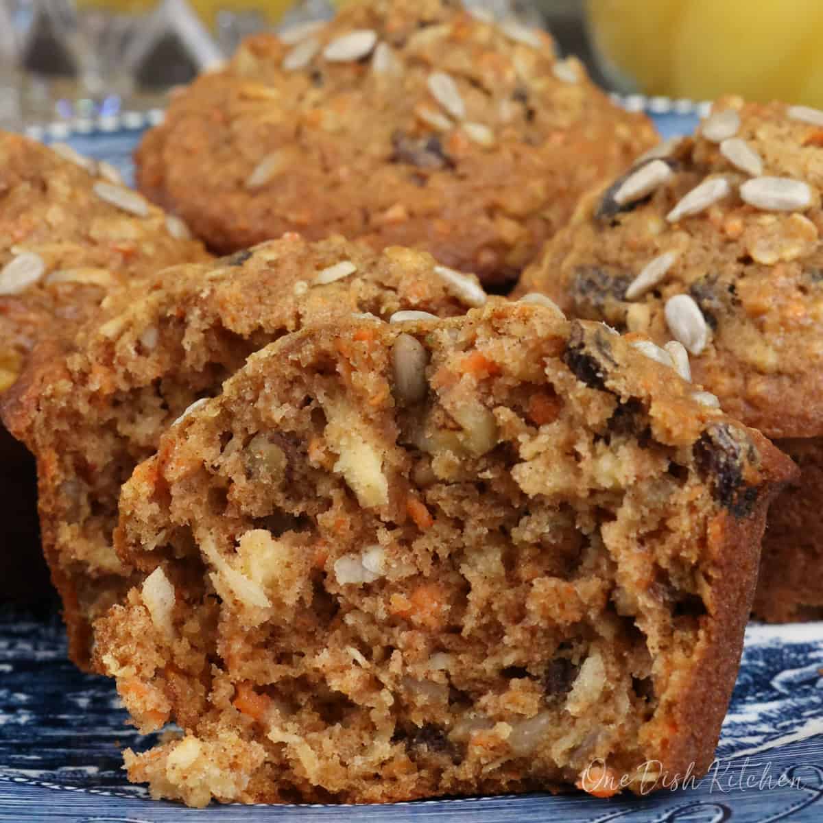 a single morning glory muffin sliced in half on a plate.