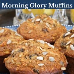 four morning glory muffins on a blue plate next to a glass of orange juice.