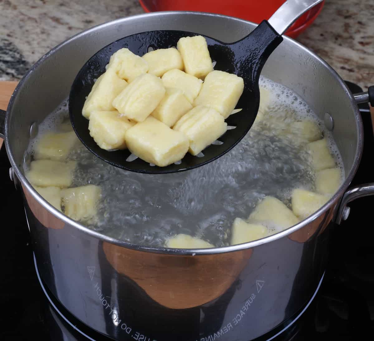 potato gnocchi cooking in a large pot of boiling water.