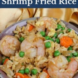 a bowl of shrimp fried rice next to a gold napkin.