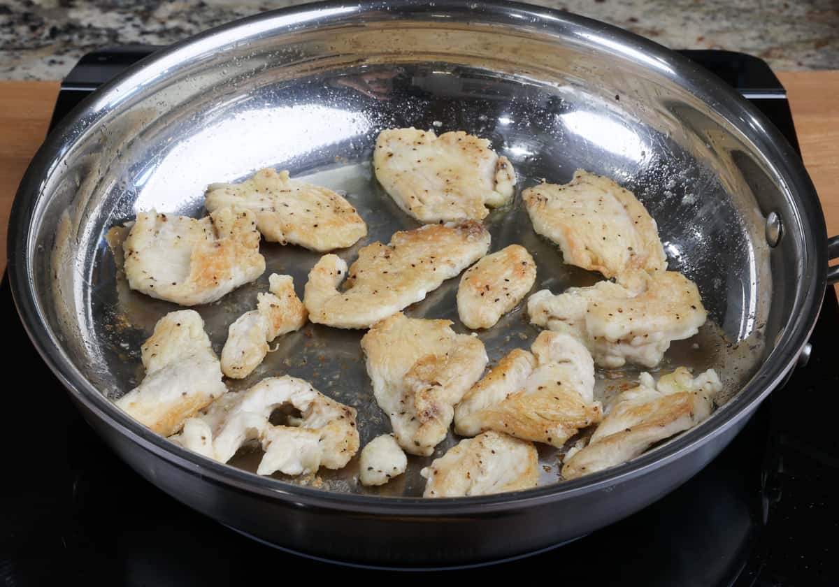 chicken browning in a skillet.