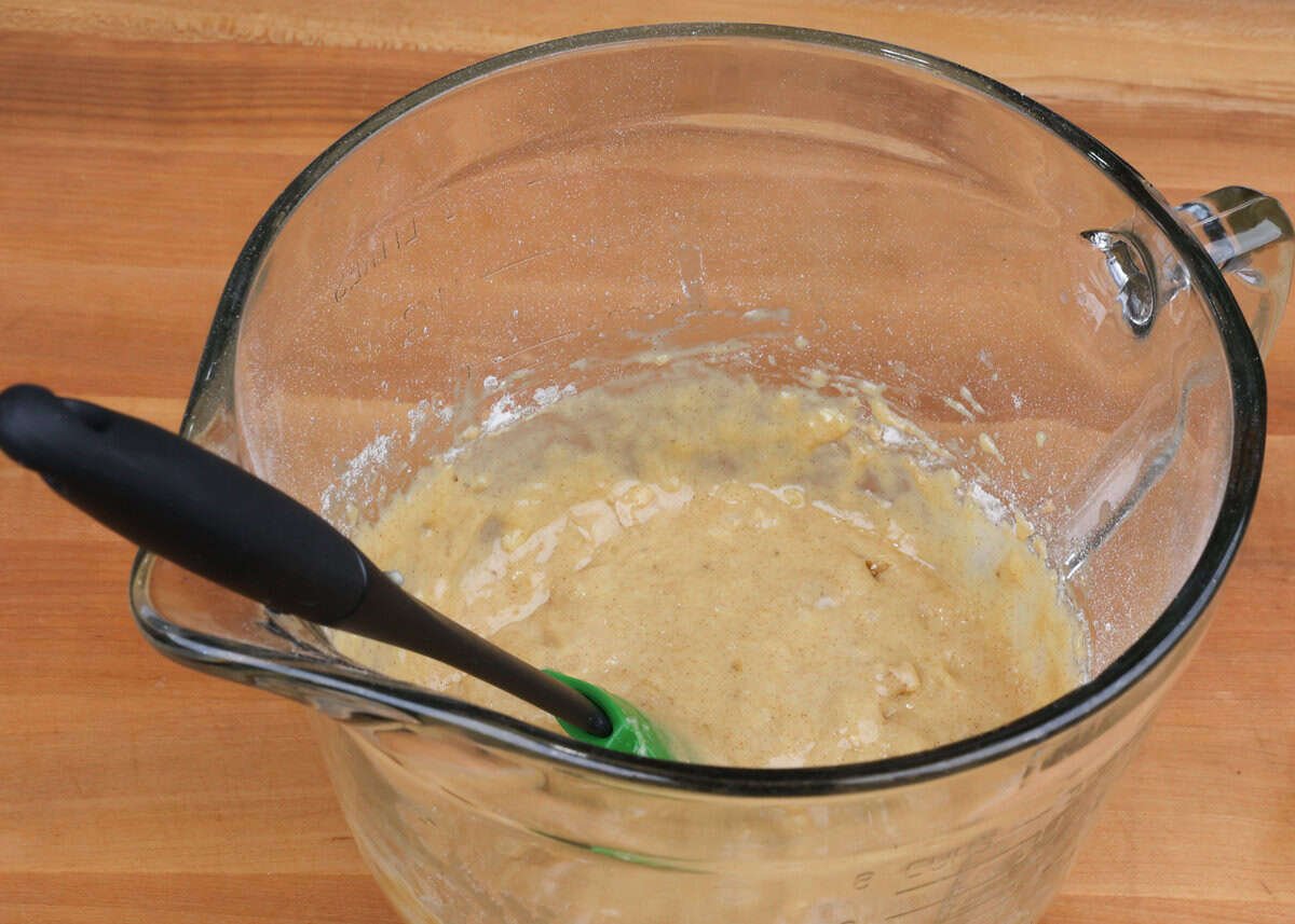 walnuts folded into banana bread batter in a mixing bowl.
