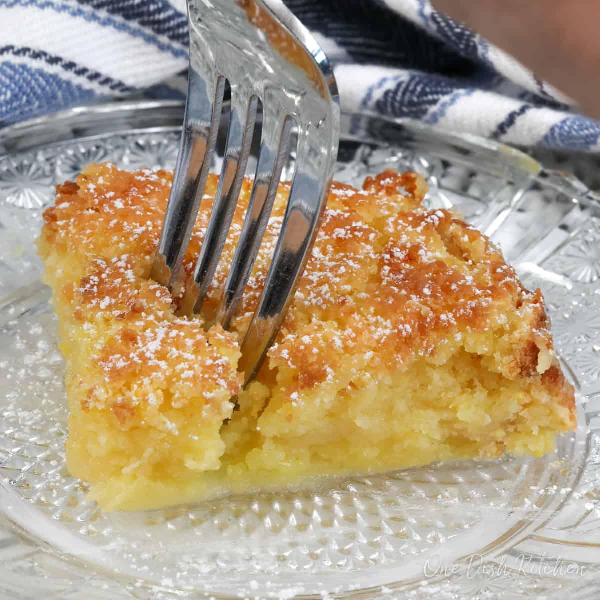 a square slice of chess pie with a fork in the center of the pie.