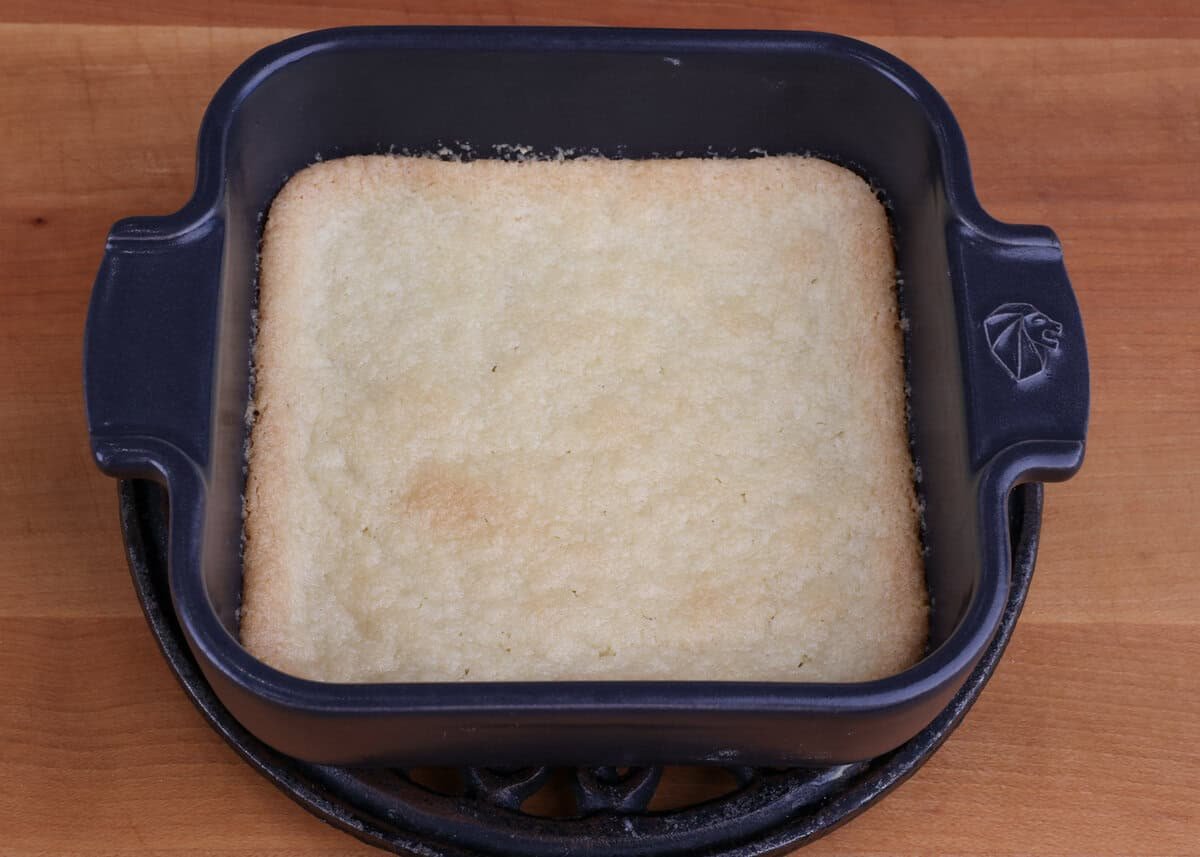 a small baked pie crust in a baking dish cooling on a kitchen counter.