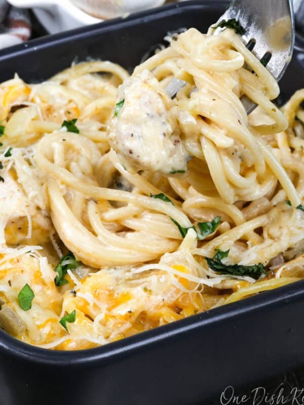 a small chicken tetrazzini with a fork on the side of the dish.