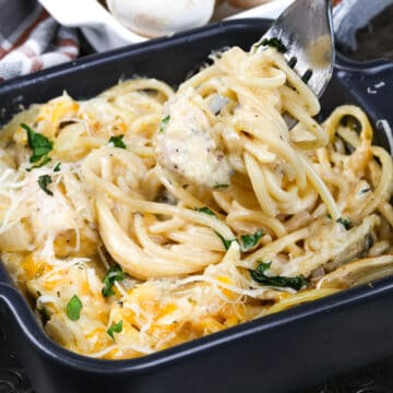 chicken tetrazzini in a small. baking dish next to a bowl of fresh whole mushrooms