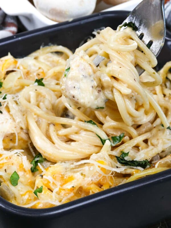 chicken tetrazzini in a small. baking dish next to a bowl of fresh whole mushrooms